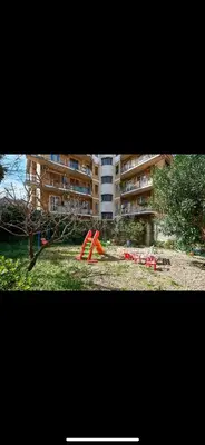 a park with red playground equipment in front of a building at Anastasio II apartment in Rome