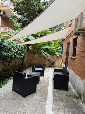 a patio with black chairs under a white umbrella at Anastasio II apartment in Rome