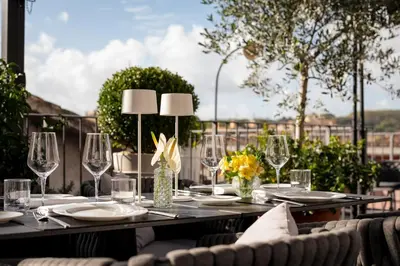 a table with wine glasses and flowers on a patio at Palazzo Navona Hotel in Rome