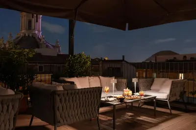 a patio with a table and chairs and an umbrella at Palazzo Navona Hotel in Rome