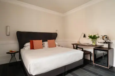 a bedroom with a white bed with orange pillows at Palazzo Navona Hotel in Rome