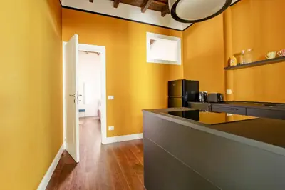 a kitchen with yellow walls and a counter in a room at CoroCoro114 Comfort ed Eleganza in Rome