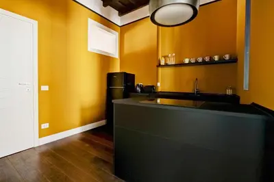 a kitchen with orange walls and a black counter top at CoroCoro114 Comfort ed Eleganza in Rome