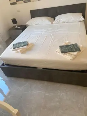 a bed with two towels sitting on top of it at Candia House in Rome