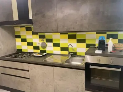 a kitchen with a sink and yellow and black tiles at Candia House in Rome