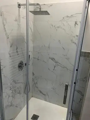 a bathroom with a shower with white marble at Candia House in Rome
