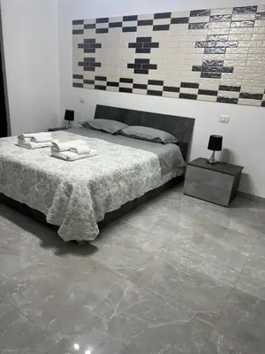 a bedroom with a bed and a tile floor at Candia House in Rome