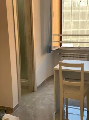a kitchen with a table and a chair next to a window at Candia House in Rome