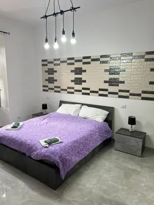 a bedroom with a purple bed with two night stands at Candia House in Rome