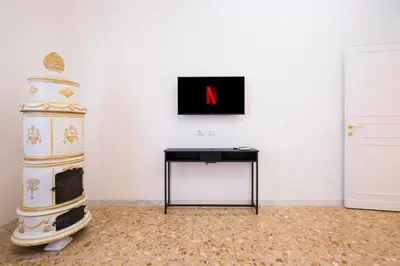 a room with a table and a television with a letter n at Savoia Luxury Penthouse in Rome