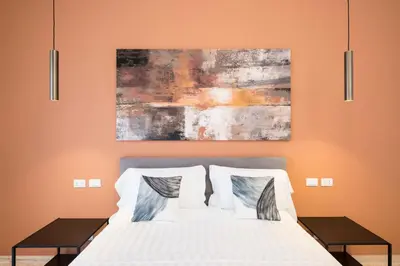 a bedroom with a bed and a painting on the wall at Savoia Luxury Penthouse in Rome