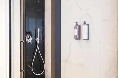 a shower with two bottles on a glass door at Savoia Luxury Penthouse in Rome