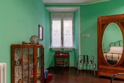 a bedroom with a bed and a green wall at GuestHost - Piazza di Roma Turquoise Apartment in Rome