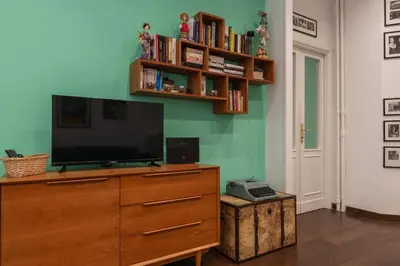 a living room with a blue couch and a window at GuestHost - Piazza di Roma Turquoise Apartment in Rome