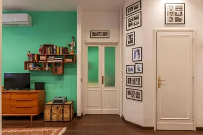 a living room with a blue couch and a table at GuestHost - Piazza di Roma Turquoise Apartment in Rome