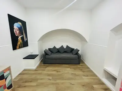 a couch in a room with a painting on the wall at Boiardo Art House in Rome