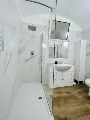 a white bathroom with a shower and a sink at Boiardo Art House in Rome