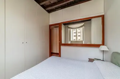 a bedroom with a white bed and a mirror at GuestHost - Campo de Fiori Unique Apartment in Rome