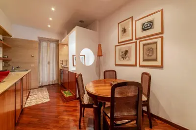 a kitchen and dining room with a wooden table and chairs at GuestHost - Campo de Fiori Unique Apartment in Rome