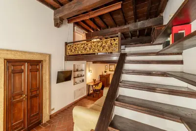 a staircase in a living room with wooden ceilings at Historical Loft at Campo de Fiori in Rome