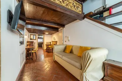 a living room with a couch and a dining room at Historical Loft at Campo de Fiori in Rome