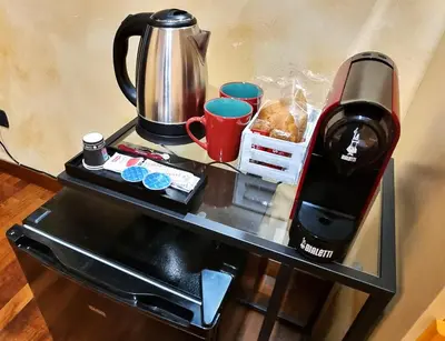 a table with a coffee maker and cups on it at Wanderlust Pietralata B&B in Rome