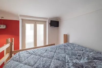 a bedroom with a bed and a television on the wall at GuestHost - Termini Live Laugh & Love Apartment in Rome