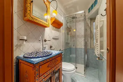 a bathroom with a toilet and a glass shower at GuestHost - Termini Live Laugh & Love Apartment in Rome