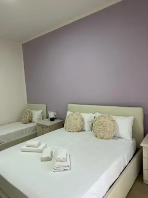 a bedroom with a large bed with white sheets at The Roman Guesthouse in Rome