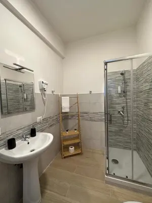 a bathroom with a sink and a shower at The Roman Guesthouse in Rome