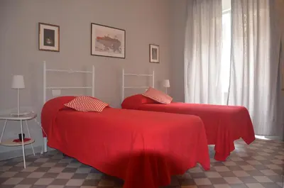 two beds with red covers in a room at Le Stanze di Pietro in Rome