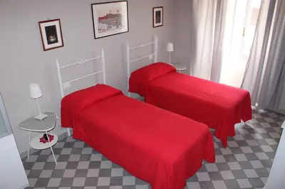 two beds with red covers in a room at Le Stanze di Pietro in Rome