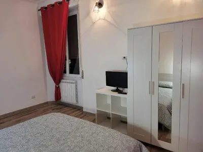 a bedroom with a bed and a desk with a television at in the garden in Rome