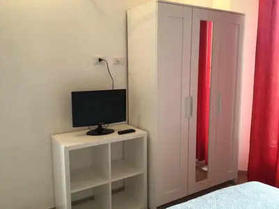 a television on a white table in a bedroom at in the garden in Rome