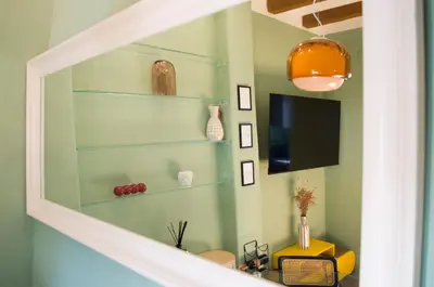 a living room with green walls and shelves at Navona Penthouse - Attico Vista Cupola 4 posti in Rome