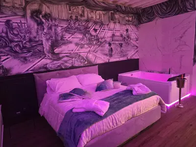 a purple room with a bed with a painting on the wall at Mirror Suite Roma Colosseo Monti con Jacuzzi in Rome
