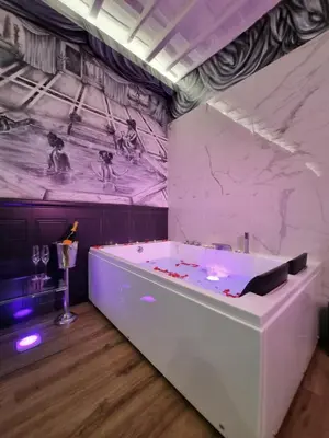 a room with a bath tub with a painting on the wall at Mirror Suite Roma Colosseo Monti con Jacuzzi in Rome