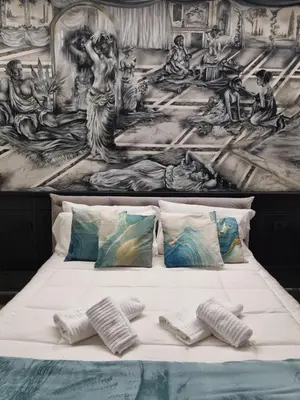 a white bed with a painting on the wall at Mirror Suite Roma Colosseo Monti con Jacuzzi in Rome