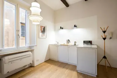a white kitchen with a sink and a window at Cinque Loft in Rome