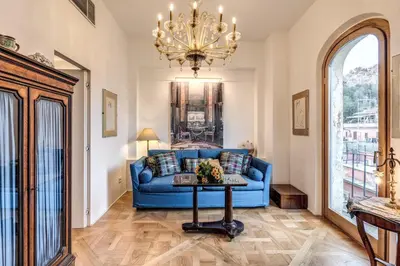 a living room with a blue couch and a chandelier at Trastevere Outstanding 4 BR Terraced Apartment in Rome