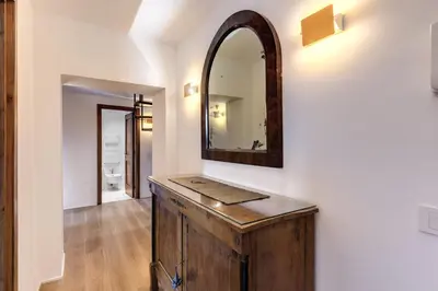 a bathroom with a wooden vanity and a mirror at Trastevere Outstanding 4 BR Terraced Apartment in Rome