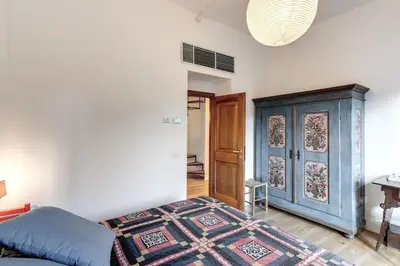 a bedroom with a bed and a blue cabinet at Trastevere Outstanding 4 BR Terraced Apartment in Rome