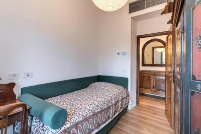 a bedroom with a bed and a table and a mirror at Trastevere Outstanding 4 BR Terraced Apartment in Rome