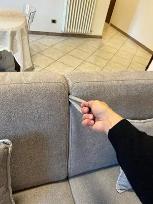 a hand is holding the corner of a couch at Casa dei fiori by GHOR in Rome