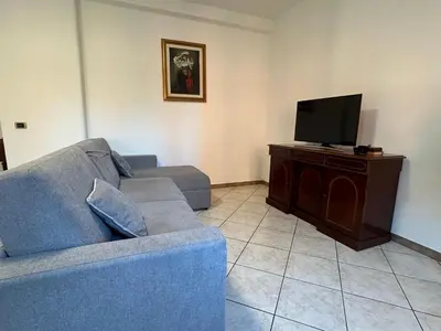 a living room with a blue couch and a flat screen tv at Casa dei fiori by GHOR in Rome