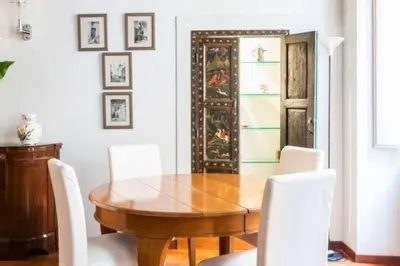a dining room with a wooden table and white chairs at Giusi Trevi Apartment in Rome