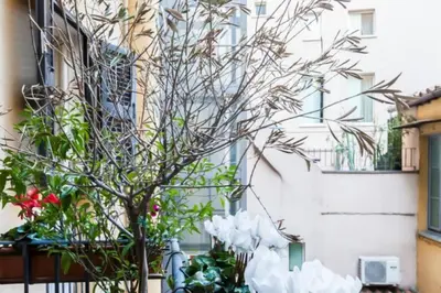 a tree with white flowers in front of a building at Giusi Trevi Apartment in Rome