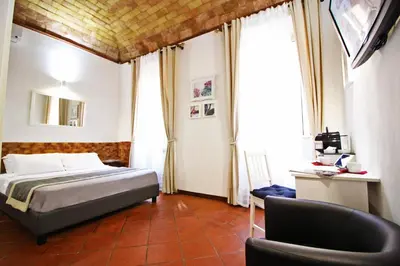 a bedroom with a bed and a desk and a chair at Machiavelli Suites in Rome