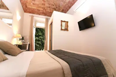 a bedroom with a bed and a television on the wall at Machiavelli Suites in Rome