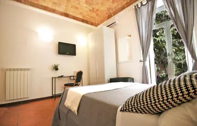 a bedroom with a bed and a window with a tv at Machiavelli Suites in Rome